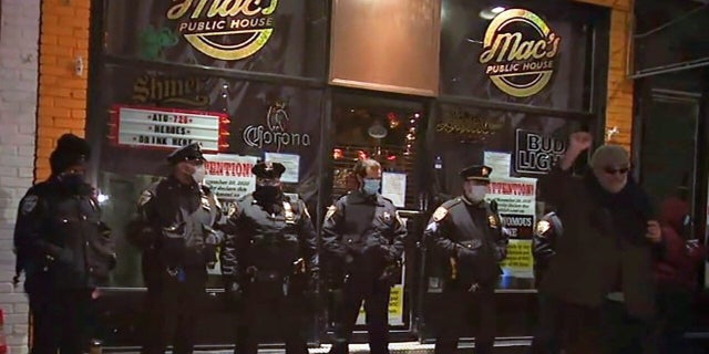 Protesters gather outside Mac's Public House on Staten Island Wednesday night to voice anger against the arrest of the bar's co-owner for allegedly refusing to obey coronavirus restrictions.