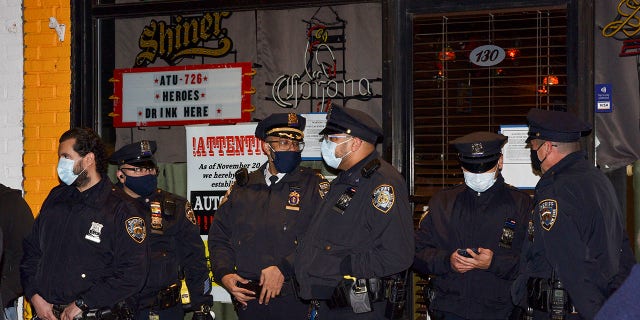 New York City sheriff's deputies stand outside Mac's Public House after co-owner Danny Presti was arrested on Tuesday. (Steve White via AP)