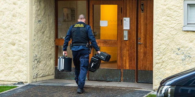 Police at the site of an apartment in which a woman is suspected of locking her son for 28 years, in Haninge, south of Stockholm. (Claudio Bresciani / TT via AP)