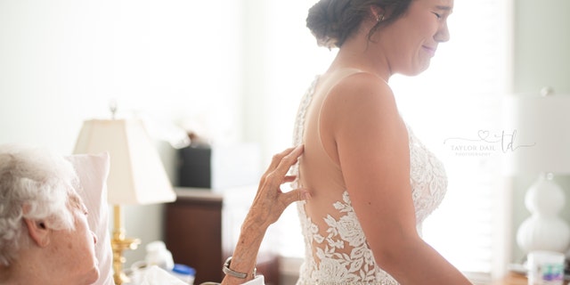 The bride cried as her grandmother touched the detailing on her back.