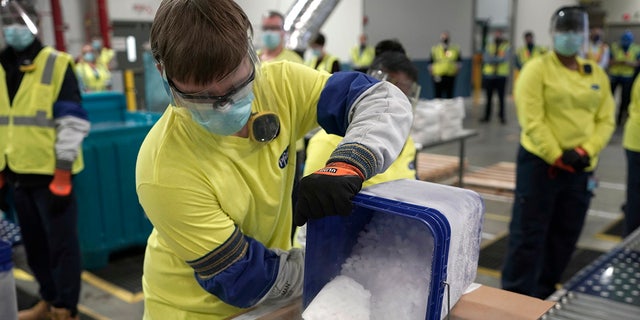 Dry ice is poured into a box containing the Pfizer-BioNTech COVID-19 vaccine as it is prepared to be shipped at the Pfizer Global Supply Kalamazoo manufacturing plant in Portage, Mich., Sunday, Dec. 13, 2020. (AP Photo/Morry Gash, Pool)
