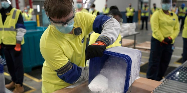 Dry ice is poured into a box containing the Pfizer-BioNTech COVID-19 vaccine as it is prepared to be shipped at the Pfizer Global Supply Kalamazoo manufacturing plant in Portage, Mich., Sunday, Dec. 13, 2020. (AP Photo/Morry Gash, Pool)