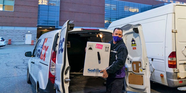 A FedEx driver delivers a box containing the Pfizer-BioNTech COVID-19 vaccine to Rhode Island Hospital in Providence, Rhode Island, Monday, Dec. 14, 2020. (AP Photo/David Goldman)