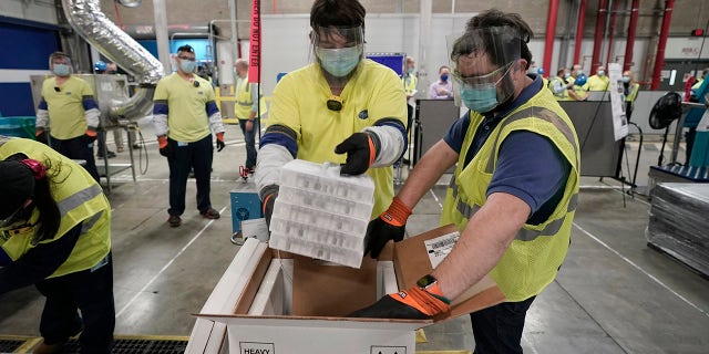 Boxes containing the Pfizer-BioNTech COVID-19 vaccine are prepared to be shipped at the Pfizer Global Supply Kalamazoo manufacturing plant in Portage, Mich., Sunday, Dec. 13, 2020. (AP Photo/Morry Gash, Pool)