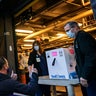 A FedEx driver gives a thumbs up after delivering a box containing the Pfizer-BioNTech COVID-19 vaccine to pharmacists Richard Emery, right, and Karen Nolan as it arrives at Rhode Island Hospital in Providence, R.I, Monday, Dec. 14, 2020.