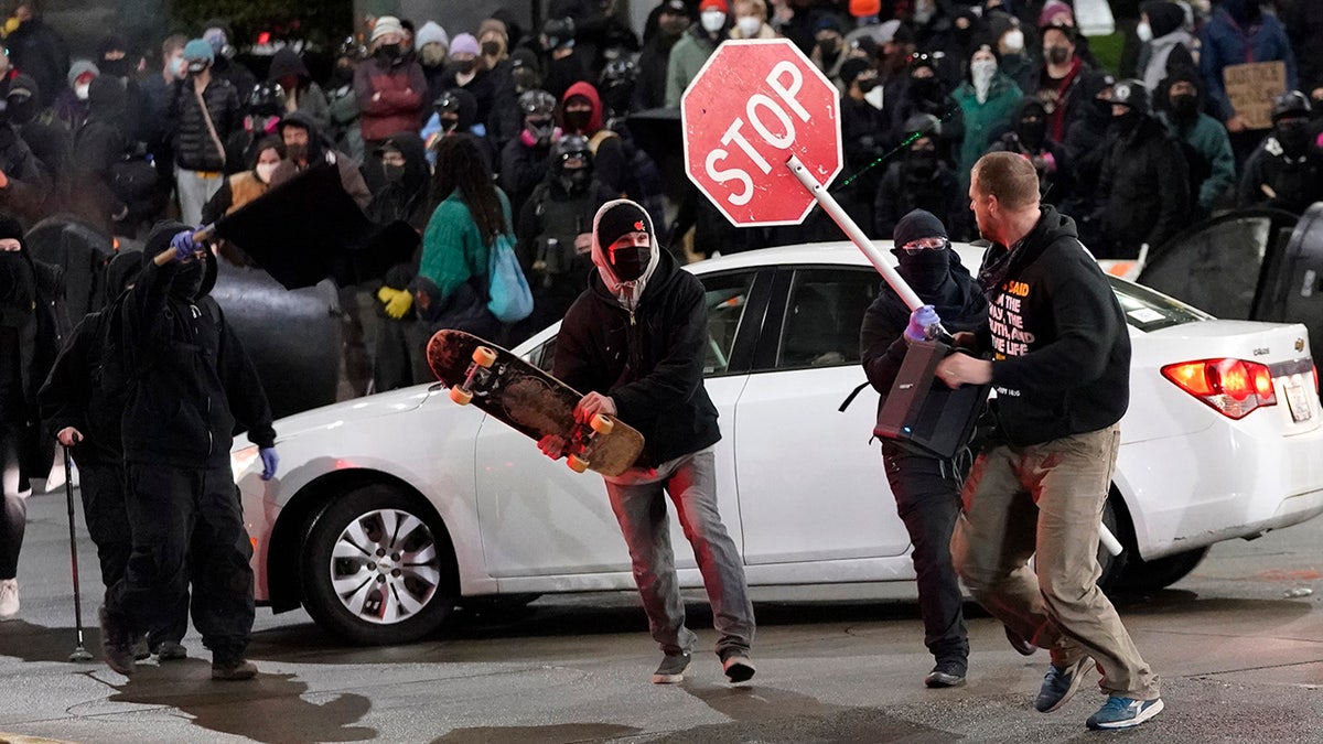 Protesters chase a street preacher, right, who was using a loudspeaker to deliver a sermon during a protest against police brutality, Sunday, Jan. 24, 2021, in downtown Tacoma, Wash. (Associated Press)