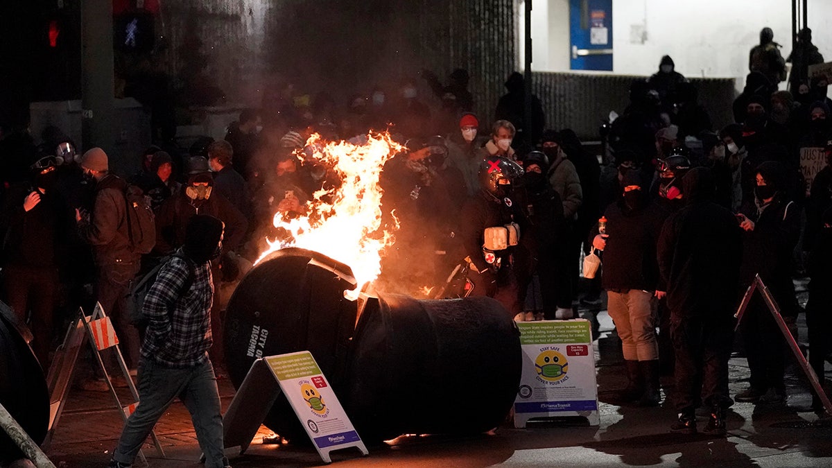 A trash can burns as people take part in a protest against police brutality, late Sunday, Jan. 24, 2021, in downtown Tacoma, Wash. (Associated Press)