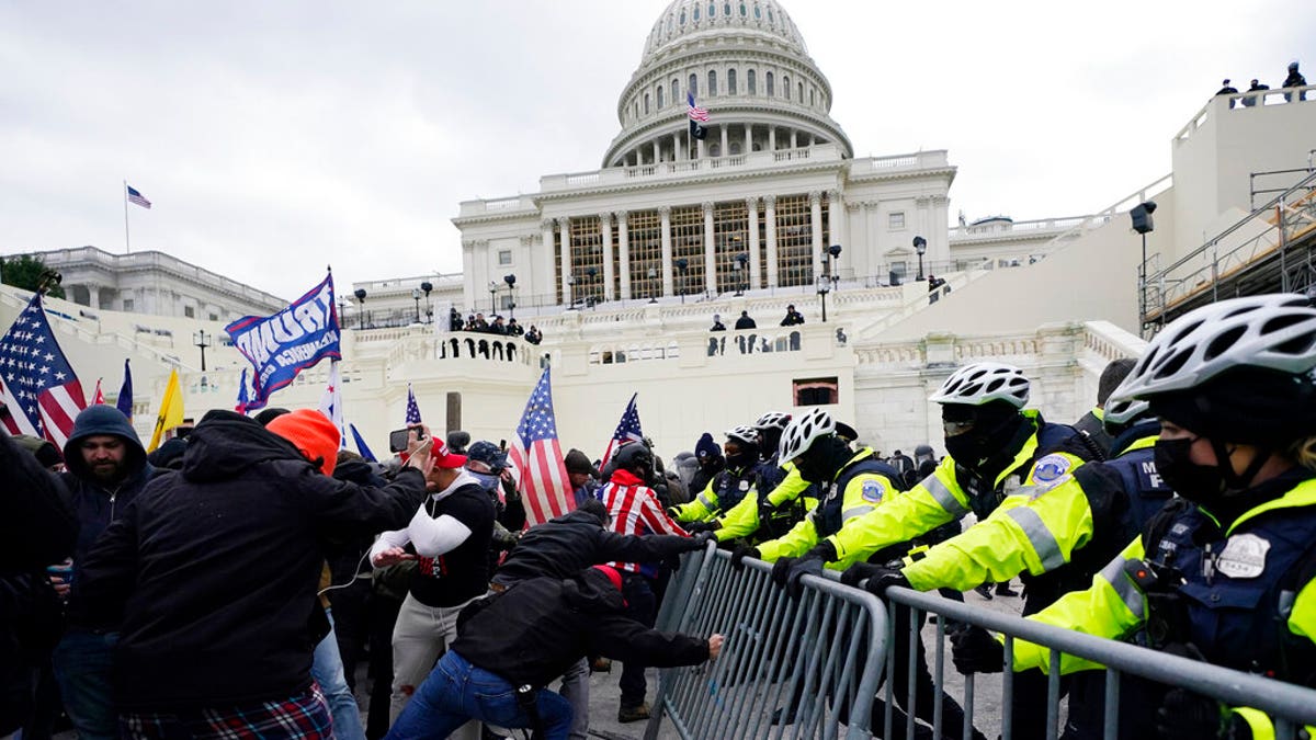 FILE: Trump supporters try to break through a police barrier at the Capitol in Washington. 