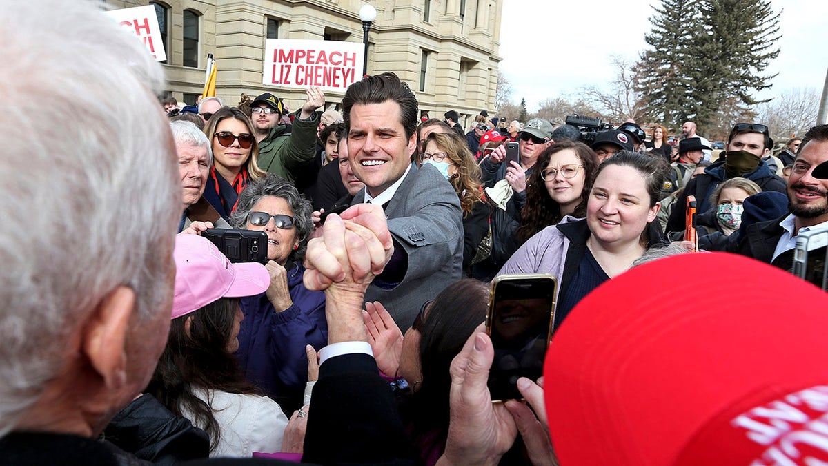 U.S. Rep. Matt Gaetz, R-Fla., grabs the hand of a supporter following a rally against U.S. Rep. Liz Cheney, R-Wyo., Thursday, Jan. 28, 2021, outside the Wyoming State Capitol in Cheyenne. Gaetz spoke to hundreds, bashing Rep. Cheney after she voted to impeach former President Donald Trump for his role in the Jan. 6 insurrection at the U.S. Capitol, and called for a group effort in finding the right nominee to replace her when she is up for reelection in 2022. (Michael Cummo/The Wyoming Tribune Eagle via AP)