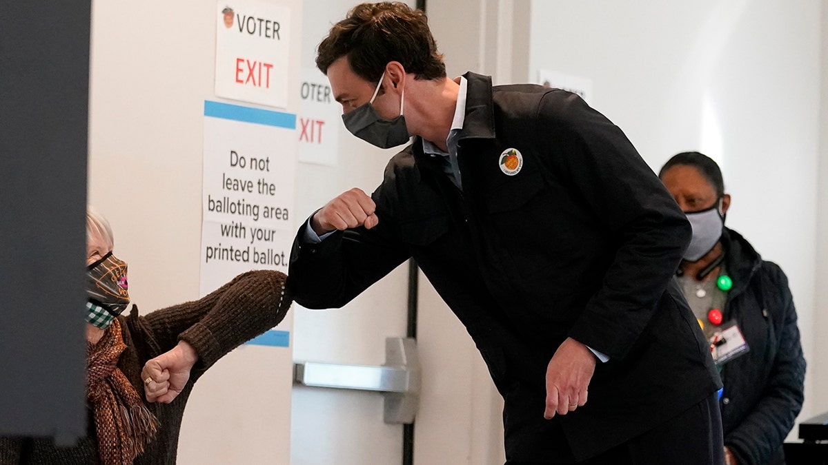Democratic nominee for U.S. Senate from Georgia Jon Ossoff greets a poll worker after voting early in Atlanta on Tuesday, Dec. 22, 2020.  (AP Photo/John Bazemore)