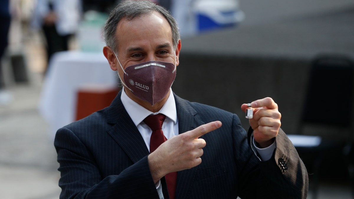 Mexico's coronavirus response leader Hugo López-Gatell points to a vial of the COVID-19 vaccine during its first applications into health workers at the General Hospital in Mexico City, early Thursday, Dec. 24, 2020. (AP Photo/Eduardo Verdugo)