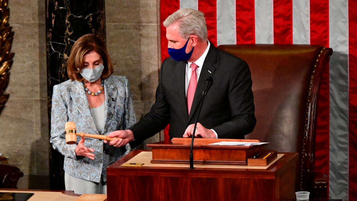 Speaker of the House Nancy Pelosi is handed the Speaker's gavel by House Minority Leader Kevin McCarthy, R-Calif., on the opening day of the 117th Congress on Capitol Hill in Washington, Sunday, Jan. 3, 2021. (Erin Scott/Pool via AP)