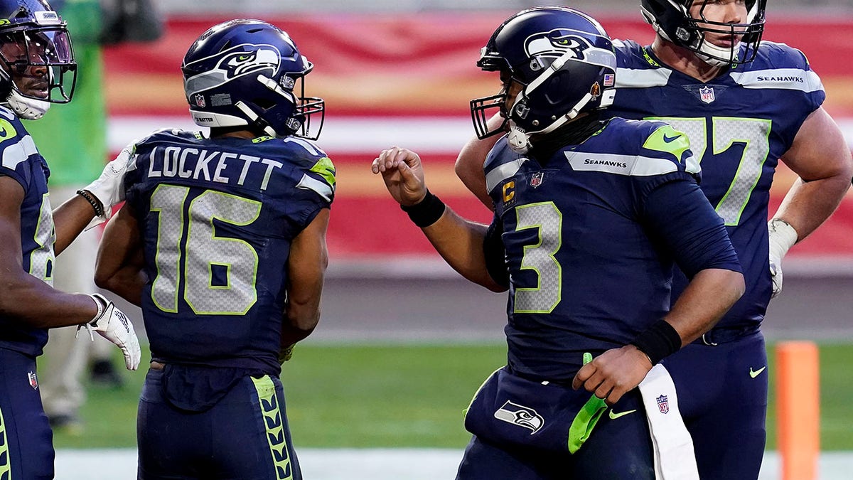 Seattle Seahawks wide receiver Tyler Lockett (16) celebrates his touchdown with quarterback Russell Wilson (3) during the second half of an NFL football game against the San Francisco 49ers, Sunday, Jan. 3, 2021, in Glendale, Ariz. (AP Photo/Ross D. Franklin)