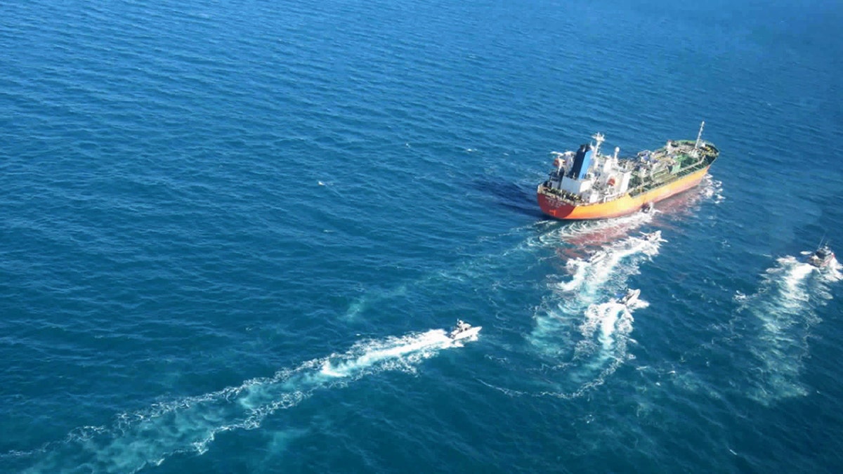 In this photo released Monday, Jan. 4, 2021, by Tasnim News Agency, the MT Hankuk Chemi, a South Korean-flagged tanker is escorted by Iranian Revolutionary Guard boats on the Persian Gulf. Iranian state television acknowledged that Tehran seized the oil tanker in the Strait of Hormuz. The report on Monday alleged the MT Hankuk Chemi had been stopped by Iranian authorities over alleged "oil pollution" in the Persian Gulf and the strait. (Tasnim News Agency via AP)