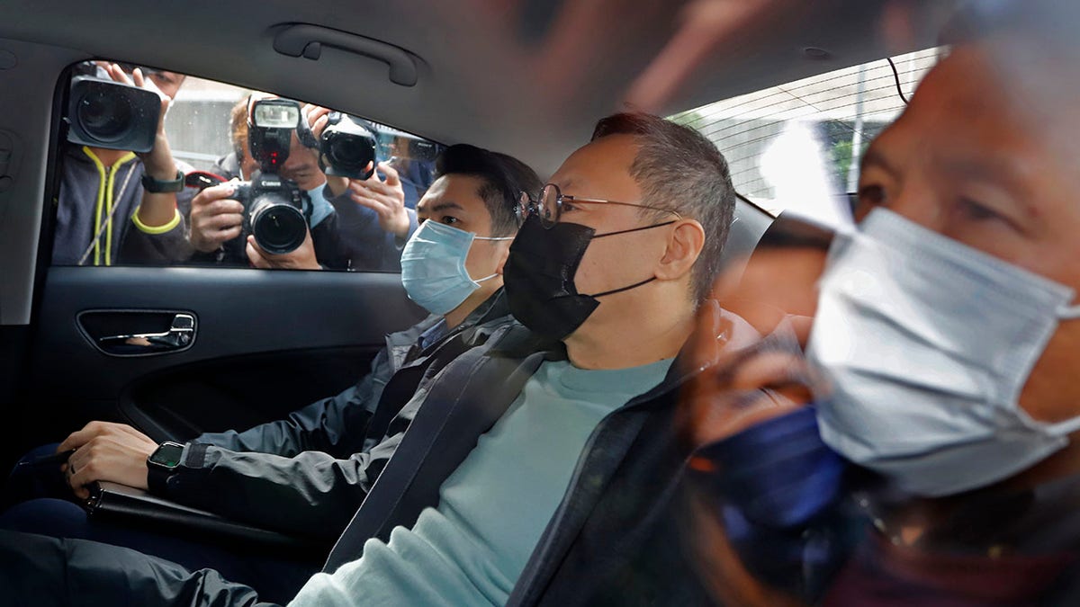 Former law professor Benny Tai, center, a key figure in Hong Kong's 2014 Occupy Central protests and also was one of the main organizers of the primaries, sits in a car after being arrested by police in Hong Kong, Wednesday, Jan. 6, 2021. About 50 Hong Kong pro-democracy figures were arrested by police on Wednesday under a national security law, following their involvement in an unofficial primary election last year held to increase their chances of controlling the legislature, according to local media reports. (AP Photo/Apple Daily)