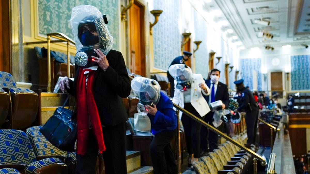 People shelter in the House gallery as protesters try to break into the House Chamber at the U.S. Capitol on Wednesday, Jan. 6, 2021, in Washington. (AP Photo/Andrew Harnik)