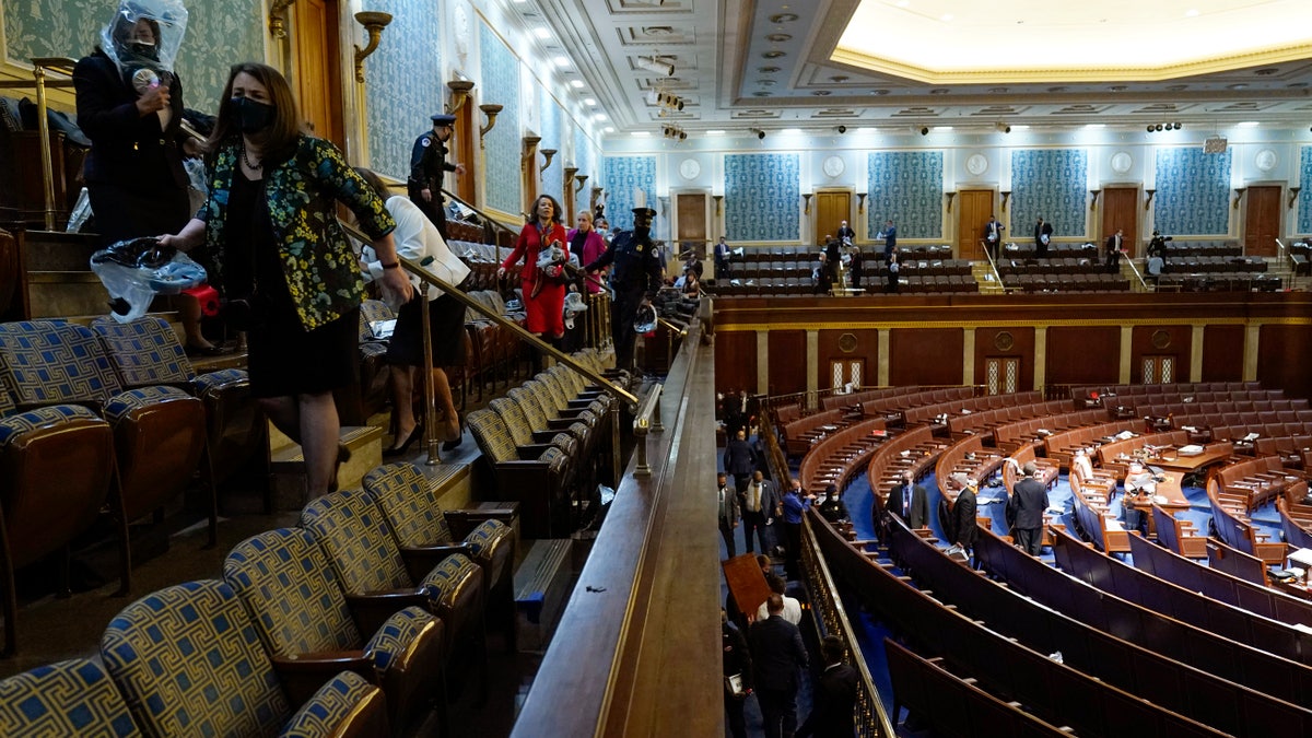 People shelter in the House gallery as protesters try to break into the House Chamber at the U.S. Capitol on Wednesday, Jan. 6, 2021, in Washington. (AP Photo/Andrew Harnik)