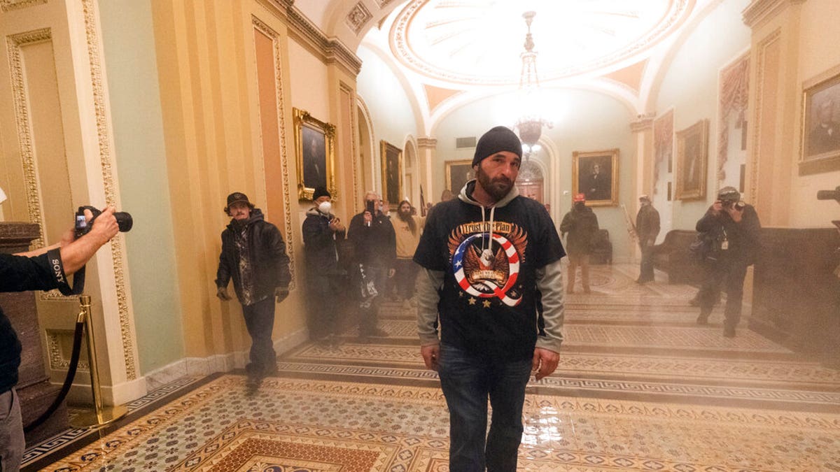 Smoke fills the walkway outside the Senate Chamber as supporters of President Donald Trump are confronted by U.S. Capitol Police officers inside the Capitol,  Jan. 6, in Washington. (AP Photo/Manuel Balce Ceneta)