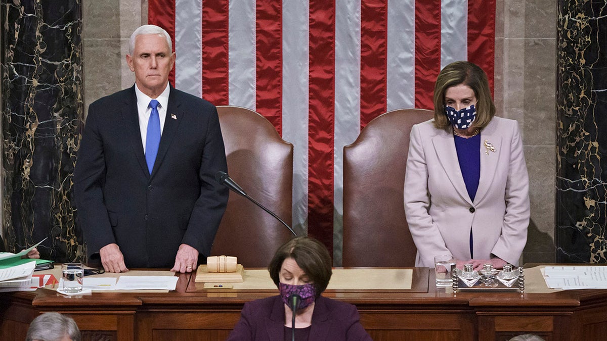 Vice President Mike Pence and Speaker of the House Nancy Pelosi, D-Calif., read the final certification of Electoral College votes cast in November's presidential election during a joint session of Congress after working through the night, at the Capitol in Washington, Thursday, Jan. 7, 2021. (AP Photo/J. Scott Applewhite, Pool)