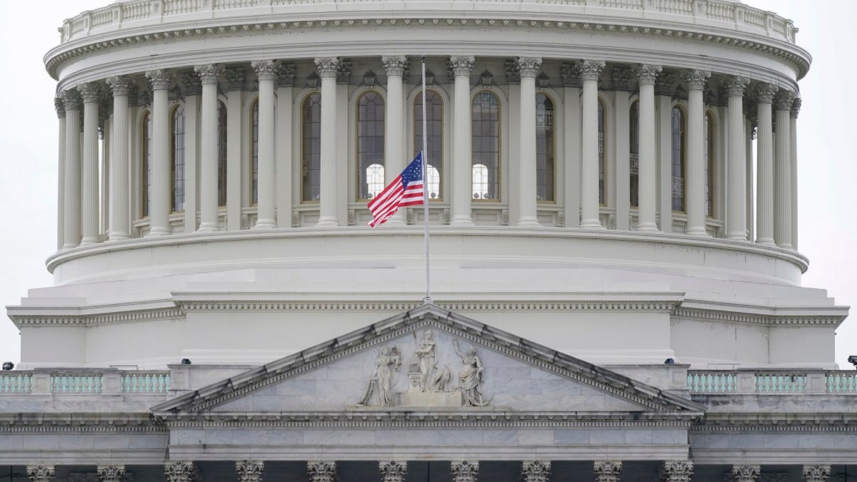An American flag flies at half-staff in remembrance of U.S. Capitol Police Officer Brian Sicknick above the Capitol Building in Washington on Friday. A Pennsylvania teacher has been put on leave pending an investigation into his involvement in the protest before the riot in the Capitol. (AP Photo/Patrick Semansky)