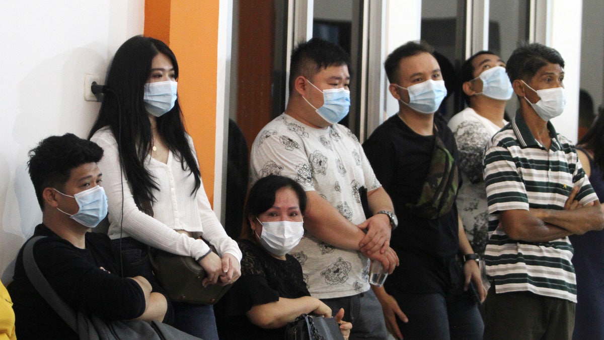 People wait for news of relatives on a Sriwijaya Air passenger jet that lost contact with air traffic controllers after takeoff at Soepadio International Airport in Pontianak, West Kalimantan, Indonesia, Saturday, Jan. 9, 2021. (AP Photo/Helmansyah)