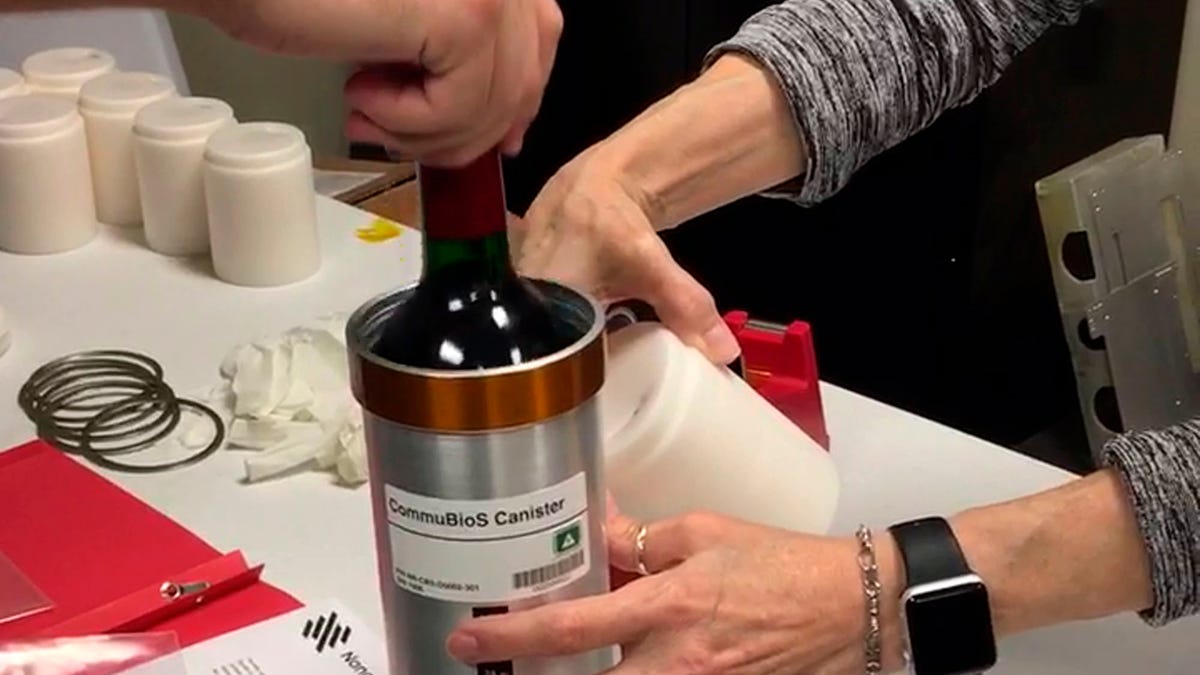 Researchers from Space Cargo Unlimited prepare bottles of French red wine to be flown from Wallops Island, Va., to the International Space Station on Nov. 2, 2019. (Space Cargo Unlimited via AP)