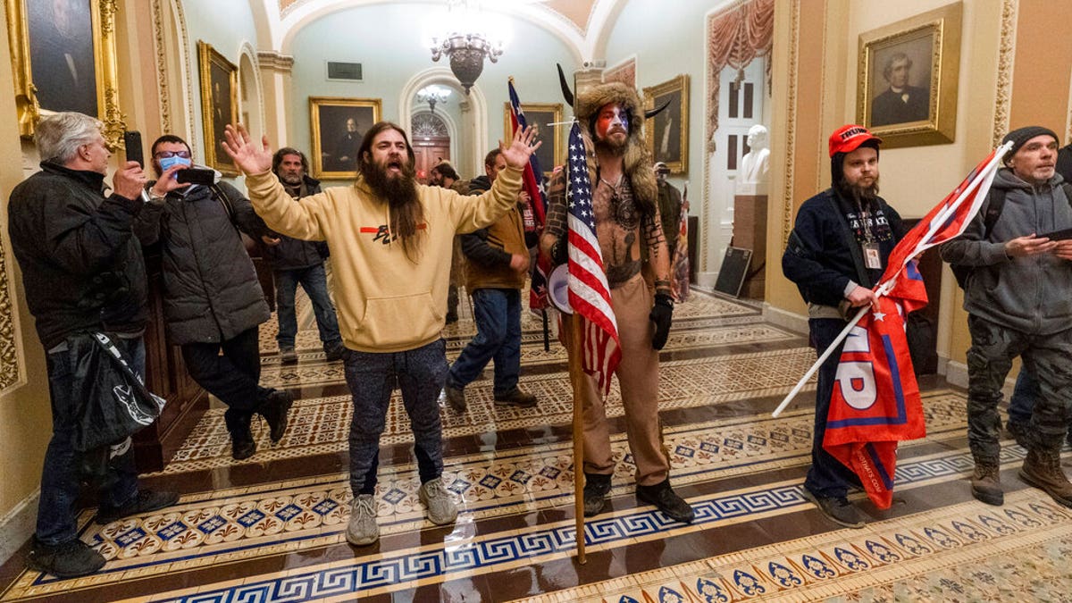 Supporters of President Donald Trump are confronted by U.S. Capitol Police officers outside the Senate Chamber inside the Capitol in Washington. 