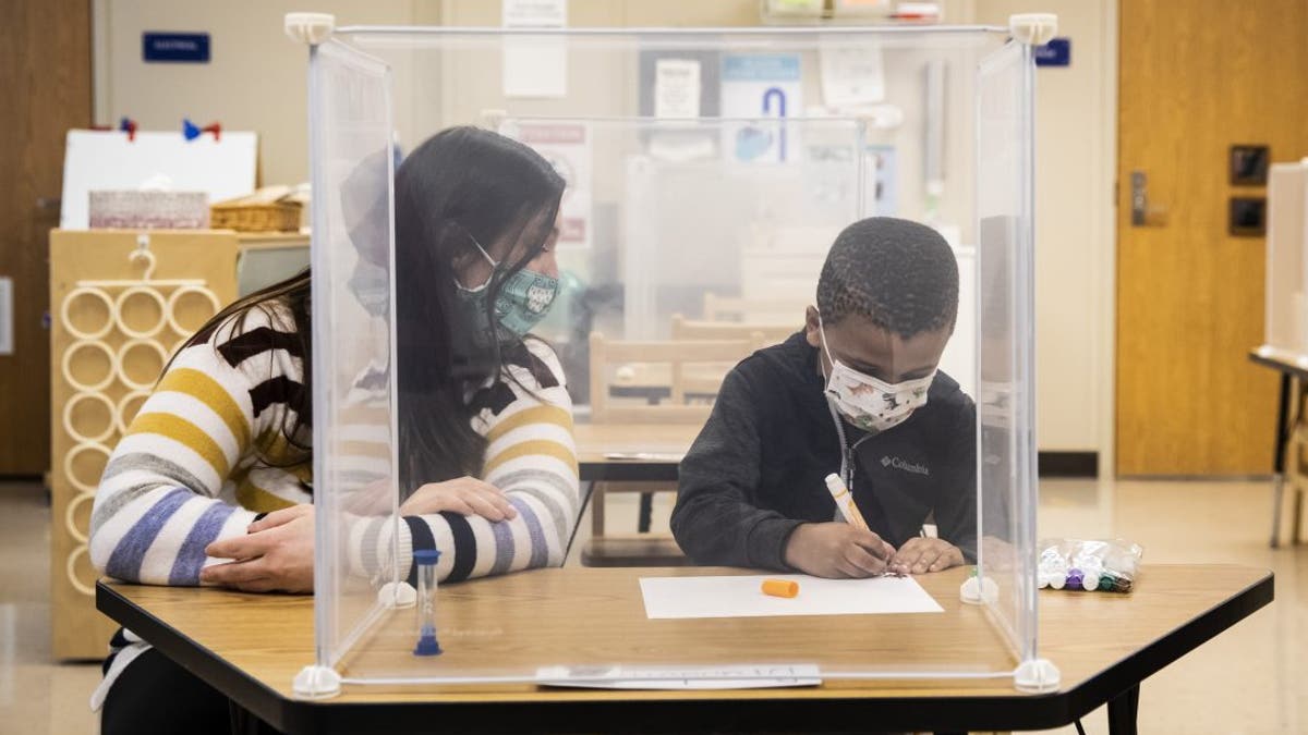 Pre-kindergarten teacher Sarah McCarthy works with a student at Dawes Elementary in Chicago, Monday, Jan. 11, 2021. (Ashlee Rezin Garcia/Chicago Sun-Times via AP, Pool)