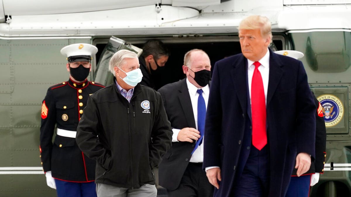 Sen. Lindsey Graham, R-S.C., left, walks with President Donald Trump as they board Air Force One upon arrival at Valley International Airport, Tuesday, Jan. 12, 2021, in Harlingen, Texas, after visiting a section of the border wall with Mexico in Alamo, Texas. (AP Photo/Alex Brandon)