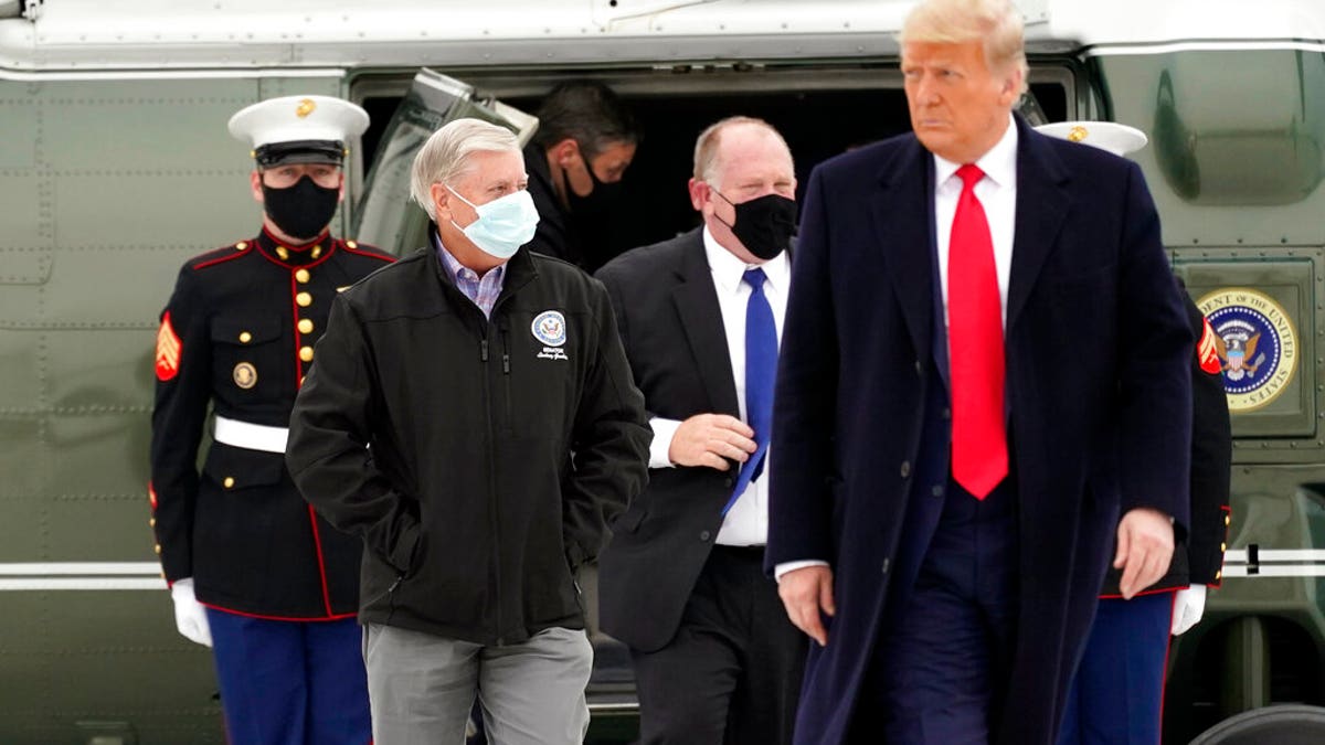 Sen. Lindsey Graham, R-S.C., left, walks with President Donald Trump as they board Air Force One upon arrival at Valley International Airport, Tuesday, Jan. 12, 2021, in Harlingen, Texas, after visiting a section of the border wall with Mexico in Alamo, Texas. (AP Photo/Alex Brandon)