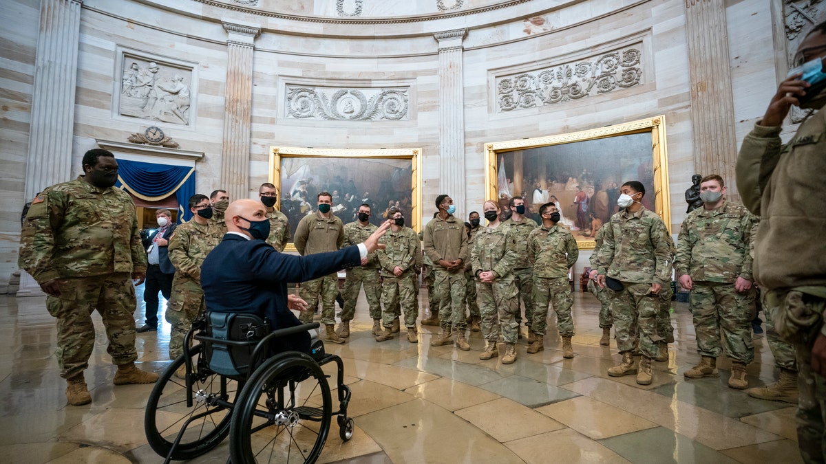Rep. Brian Mast, R-Fla., left, visits with National Guard troops who are helping with security at the Capitol Rotunda in Washington, Wednesday, Jan. 13, 2021. (AP Photo/J. Scott Applewhite)
