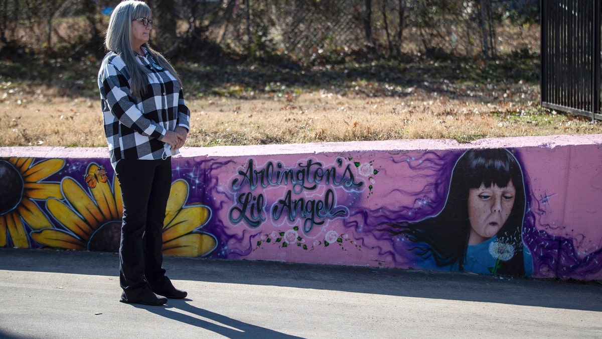 Donna Williams waits to approach the podium, Wednesday, Jan. 13, 2021, in Arlington, Texas, to speak on the 25th anniversary of the abduction and subsequent murder of her daughter, Amber Hagerman, depicted in the mural on the right. (Associated Press)