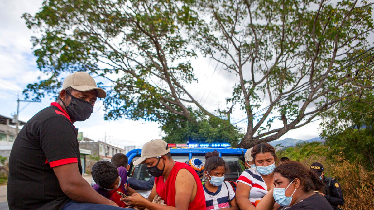 Honduran migrants sit in the bed of a police vehicle after they were detained in Chiquimula, Guatemala, Tuesday, Jan. 19, 2021. (AP Photo/Oliver de Ros)