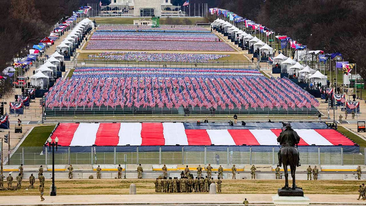 Members of the National Guard look on as American flags decorate the "Field of Flags" at the National Mall ahead of President-elect Joe Biden's inauguration ceremony, Wednesday, Jan. 20, 2021, in Washington. (Tasos Katopodis/Pool Photo via AP)