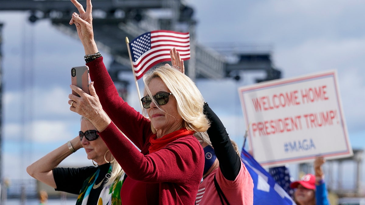 Supporters of President Donald Trump wave as the motorcade passes by on the road to Mar-a-Lago, Trump's Palm Beach estate, on Wednesday, Jan. 20, 2021, in West Palm Beach, Fla. (Associated Press)