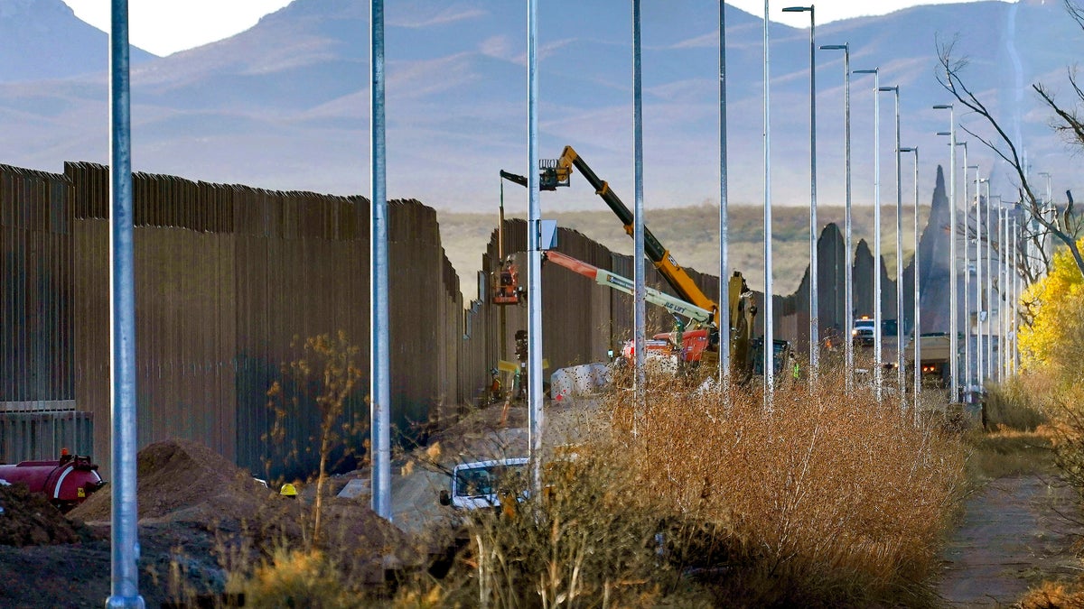 FILE - Crews construct a section of border wall in San Bernardino National Wildlife Refuge, Tuesday, Dec. 8, 2020, in Douglas, Ariz. President Biden on Wednesday ordered a "pause" on all wall construction within a week. (AP Photo/Matt York)