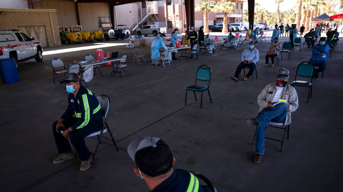 Farmworkers wait in the holding area after getting the Pfizer-BioNTech COVID-19 vaccine at Tudor Ranch in Mecca, Calif., Thursday, Jan. 21, 2021.