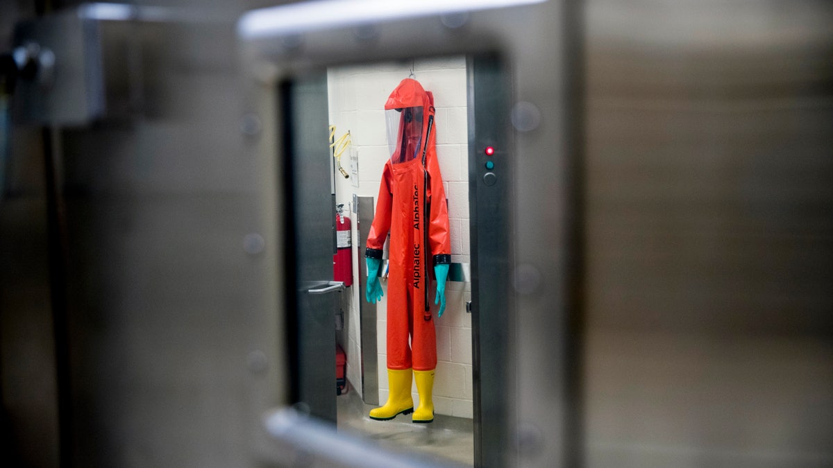 FILE - In this March 19, 2020, file photo, a biosafety protective suit for handling viral diseases are hung up in a biosafety level 4 training facility at U.S. Army Medical Research and Development Command at Fort Detrick in Frederick, Md., where scientists are working to help develop solutions to prevent, detect and treat the coronavirus. China is trying to spread doubt about the effectiveness of Western vaccines and the origin of the coronavirus as a World Health Organization-selected team of scientists are in the city where the pandemic first broke out. (AP Photo/Andrew Harnik, File)