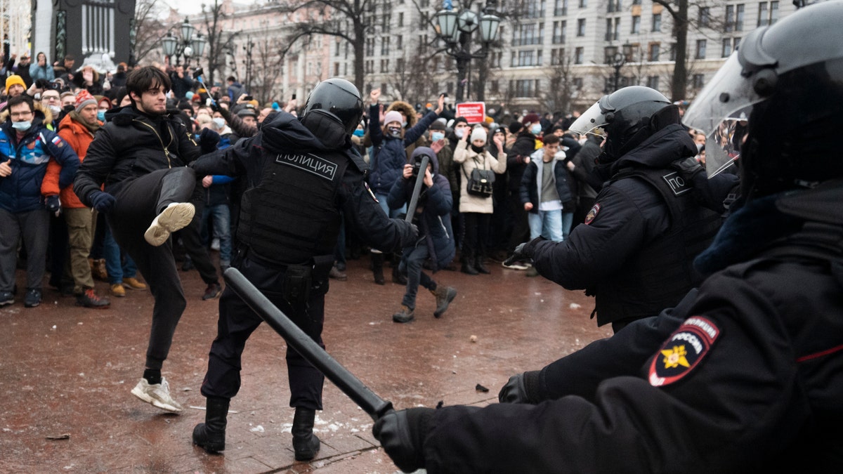 A demonstrator clashes with a police officer during a protest against the jailing of opposition leader Alexei Navalny in Pushkin square in Moscow, Russia, Saturday, Jan. 23, 2021. (AP Photo/Victor Berezkin)