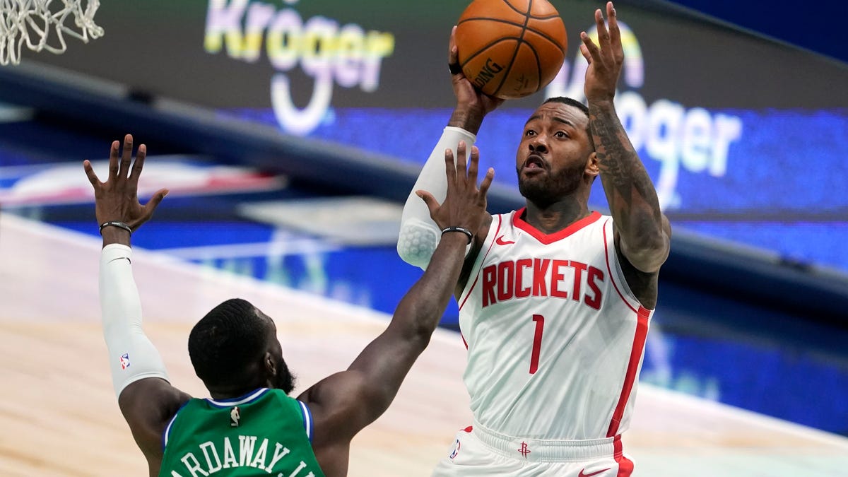 Dallas Mavericks forward Tim Hardaway Jr. (11) defends against a shot by Houston Rockets guard John Wall (1) during the second half of an NBA basketball game in Dallas, Saturday, Jan. 23, 2021. (AP Photo/Tony Gutierrez)