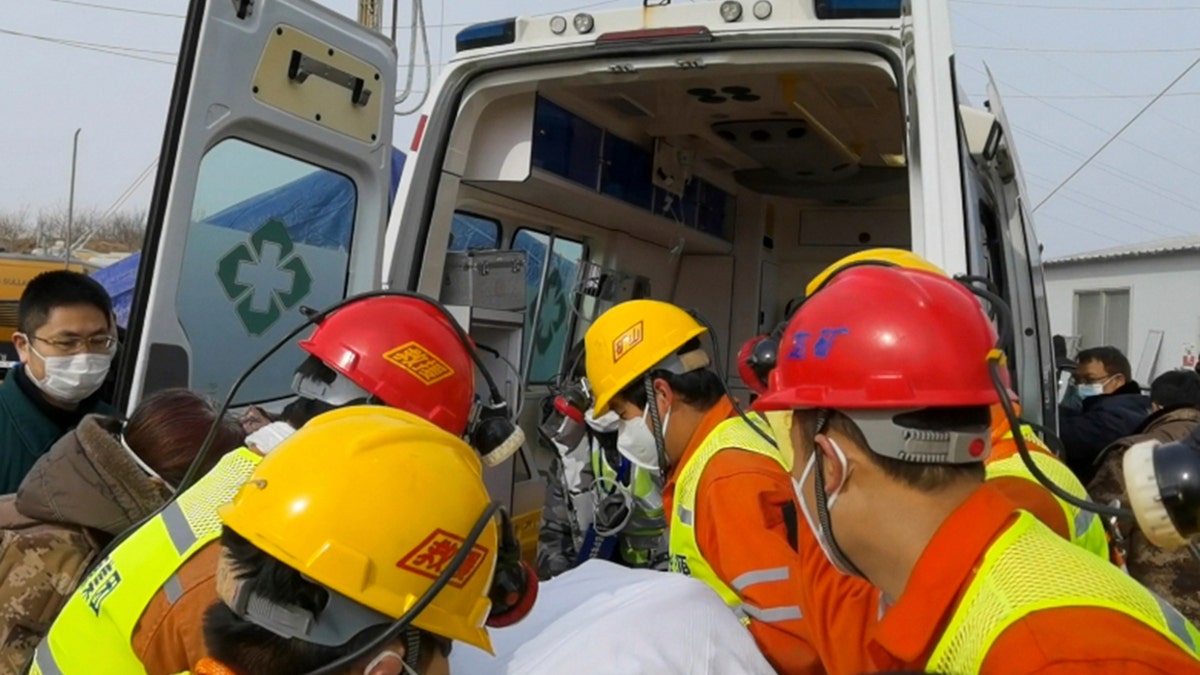 In this photo released by Xinhua News Agency, rescuers carry a miner who was trapped in a gold mine in Qixia City in east China's Shandong Province, Sunday, Jan. 24, 2021. Rescuers in China on Sunday lifted several trapped miners to the surface who were trapped for two weeks after an explosion in a northern gold mine, state media reported. (Luan Qincheng/Xinhua via AP)