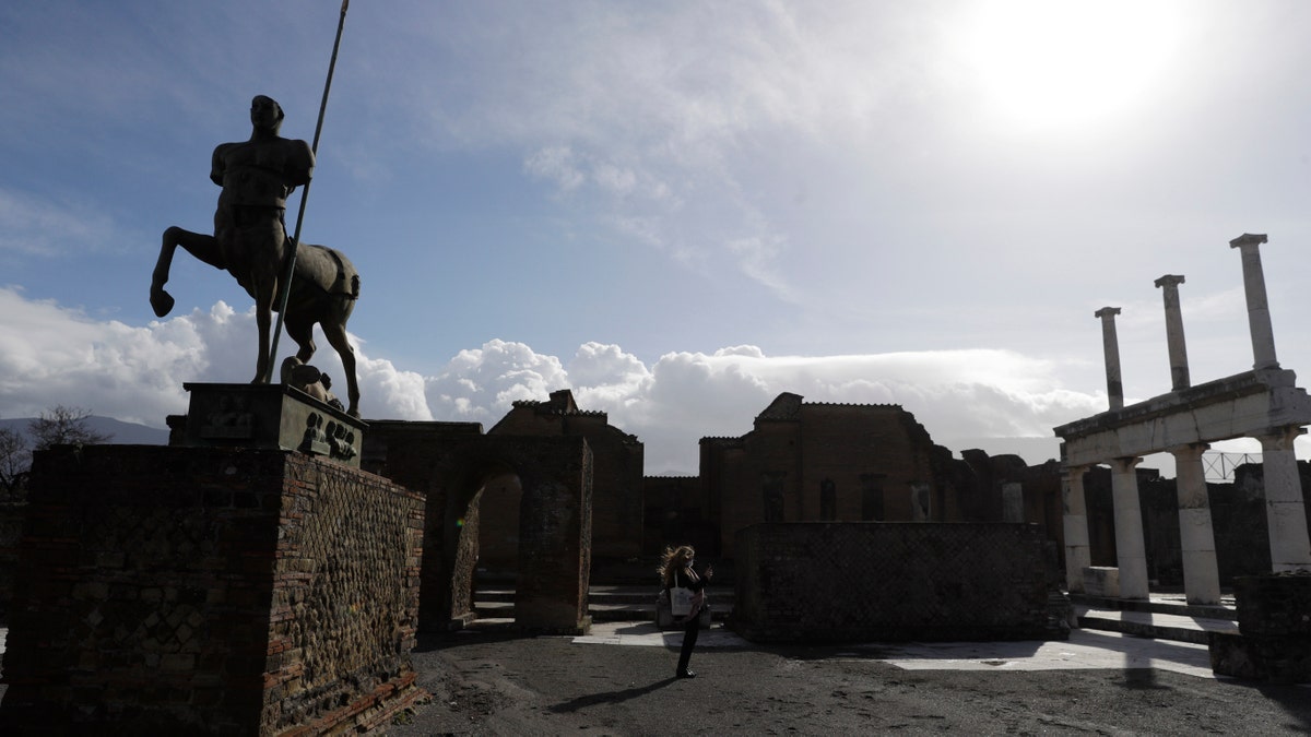 A journalist takes pictures in the archeological site of Pompeii during the inauguration of the museum Antiquarium, in Pompeii, southern Italy, Monday, Jan. 25, 2021. (AP Photo/Gregorio Borgia)