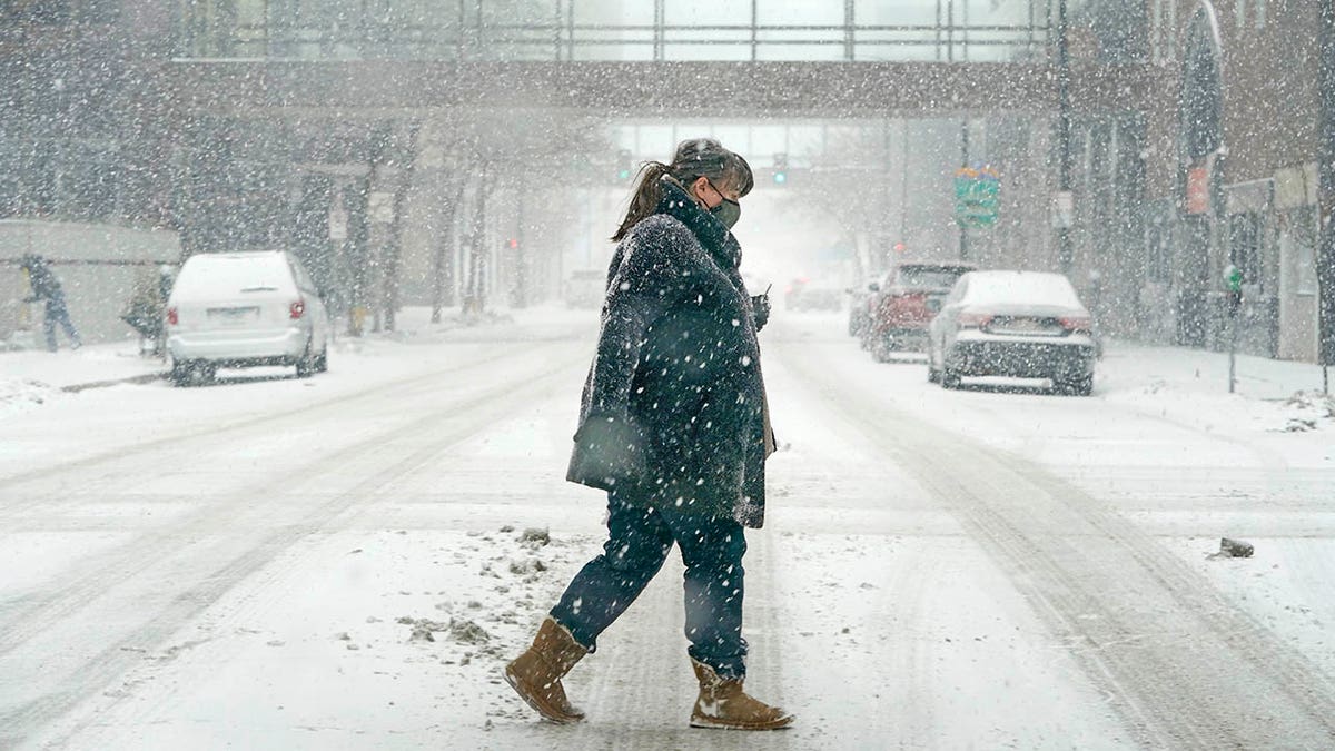 Woman crossing the street during a winter storm