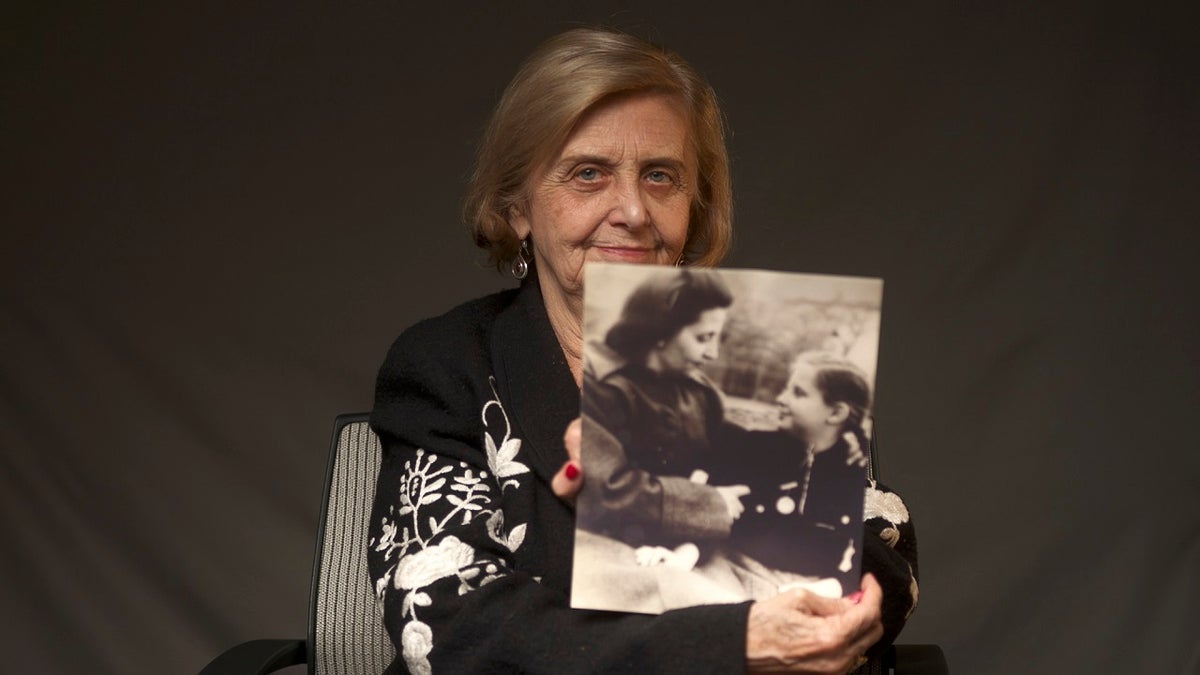 This photo provide by the World Jewish Congress, Tova Friedman, an 82-year-old Polish-born Holocaust survivor holding a photograph of herself as a child with her mother, who also survived the Nazi death camp Auschwitz, in New York, Friday, Dec.13, 2019. (World Jewish Congress via AP)