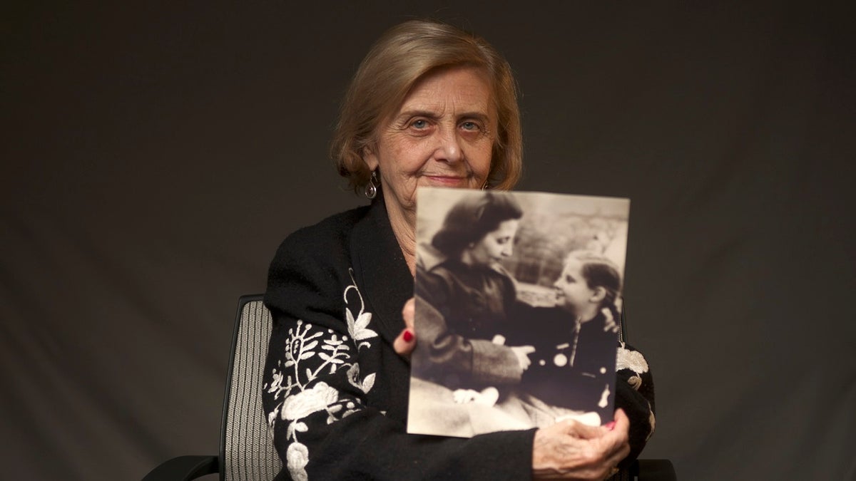 This photo provided by the World Jewish Congress, Tova Friedman, an 82-year-old Polish-born Holocaust survivor holding a photograph of herself as a child with her mother, who also survived the Nazi death camp Auschwitz, in New York, Friday, Dec.13, 2019. (World Jewish Congress via AP)