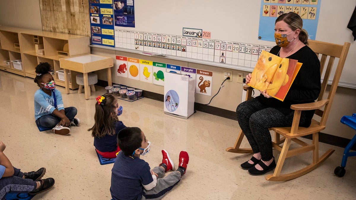 In this Jan. 11 photo, pre-kindergarten teacher Angela Panush reads a story to her students at Dawes Elementary in Chicago. Some parents have suggested they will sue to force teachers to return to classrooms for in-person instruction. (AP/Chicago Sun-Times)