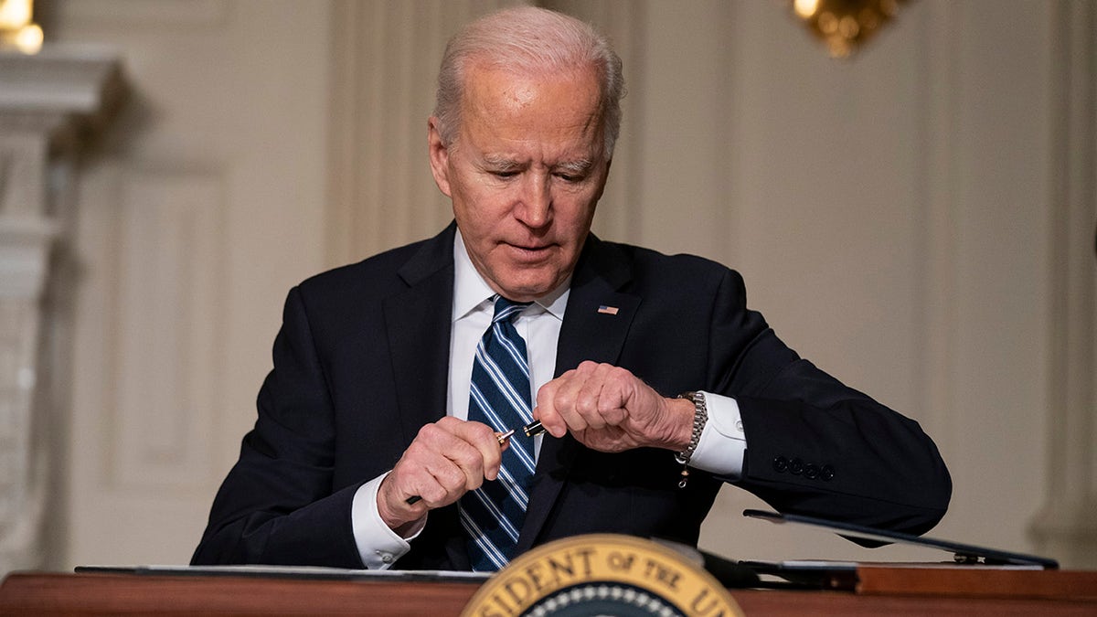 President Joe Biden signs a series of executive orders on climate change, in the State Dining Room of the White House, Wednesday, Jan. 27, 2021, in Washington. (AP Photo/Evan Vucci)