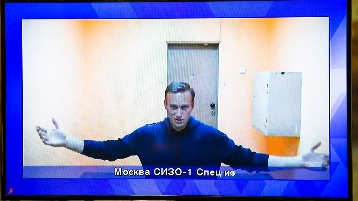 Russian opposition leader Alexei Navalny appears on a TV screen during a live session with the court during a hearing of his appeal in a court in Moscow, Russia, Thursday, Jan. 28, 2021.? (AP Photo/Alexander Zemlianichenko)