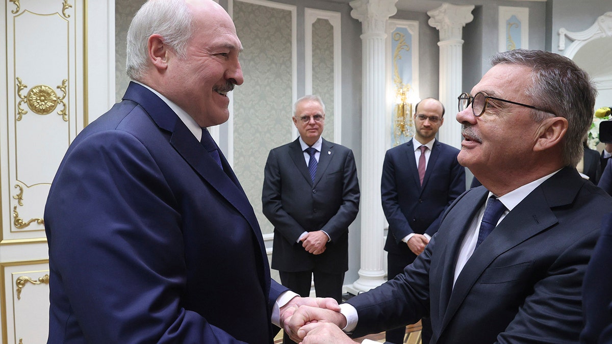 Belarusian President Alexander Lukashenko, left, greets International Ice Hockey Federation President Rene Fasel during their meeting in Minsk, Belarus, Monday, Jan. 11, 2021. White House Press Secretary Jen Psaki denied Lukashenko's allegation that the U.S. was behind a plot to assassinate him. (Nikolai Petrov/BelTA Pool Photo via AP)
