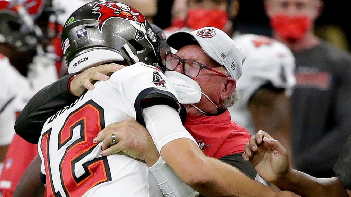 Tampa Bay Buccaneers quarterback Tom Brady hugs head coach Bruce Arians on the sidelines during the second half of an NFL divisional round playoff football game against the New Orleans Saints, Sunday, Jan. 17, 2021, in New Orleans. 